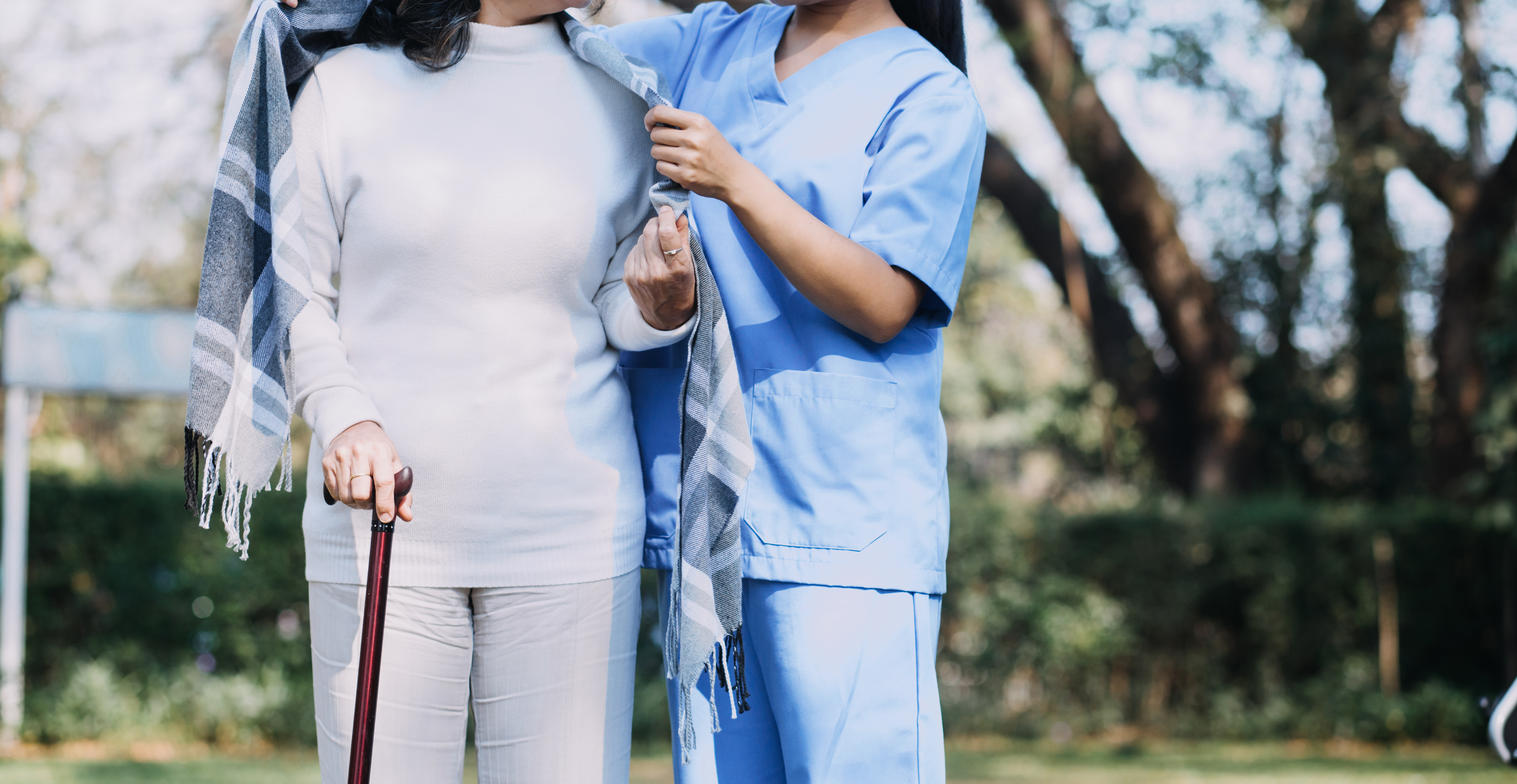 Asian caregiver supporting an older adult
