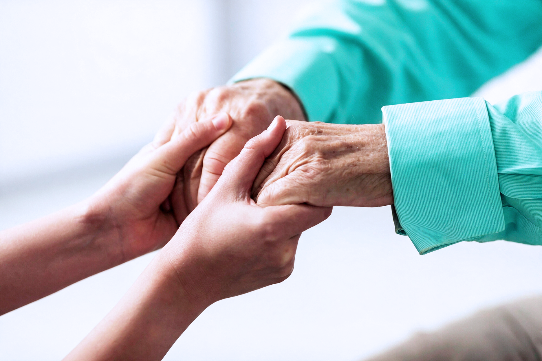 Caregiver holding an older adult's hand